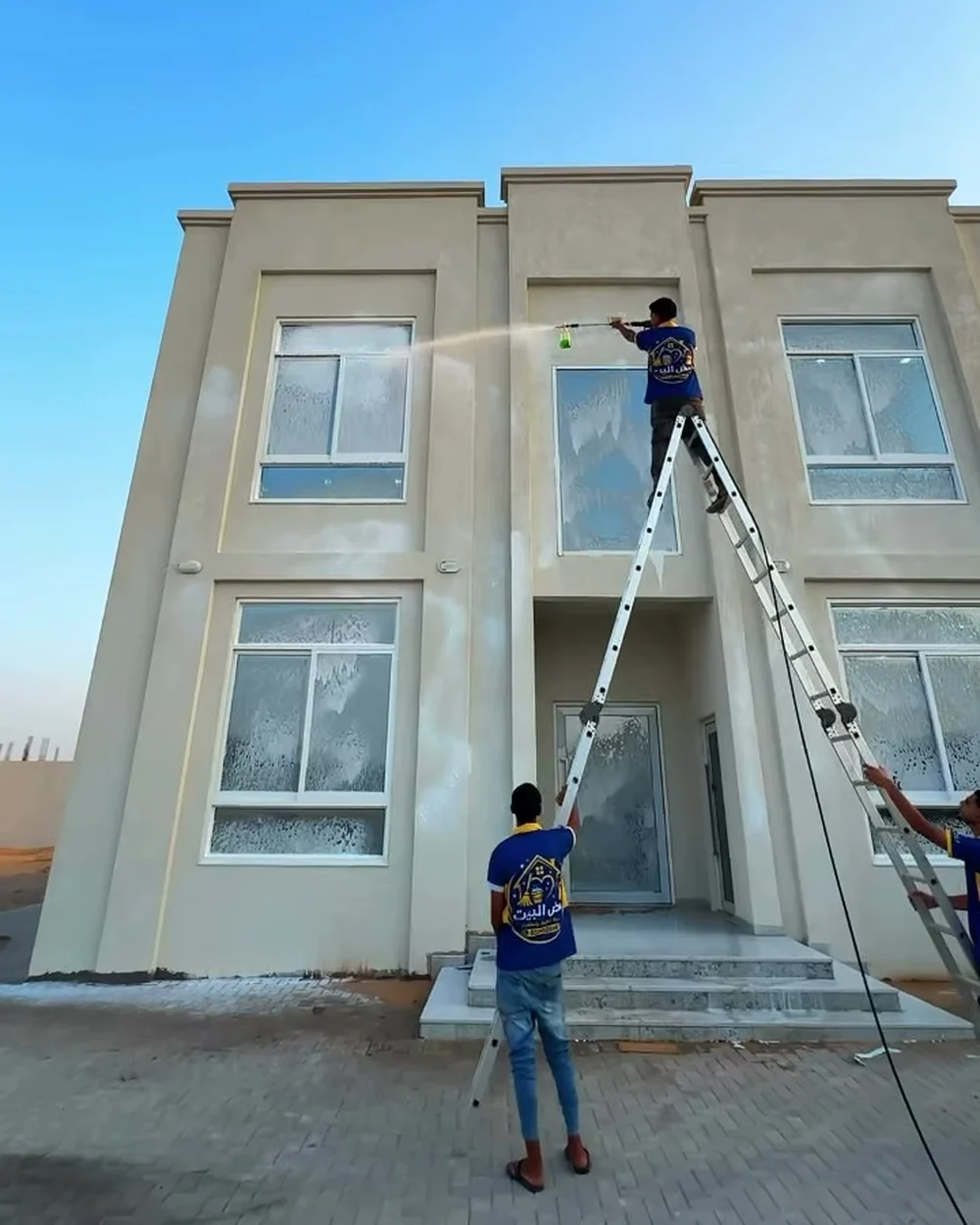 Home Beat crew pressure washing a villa facade